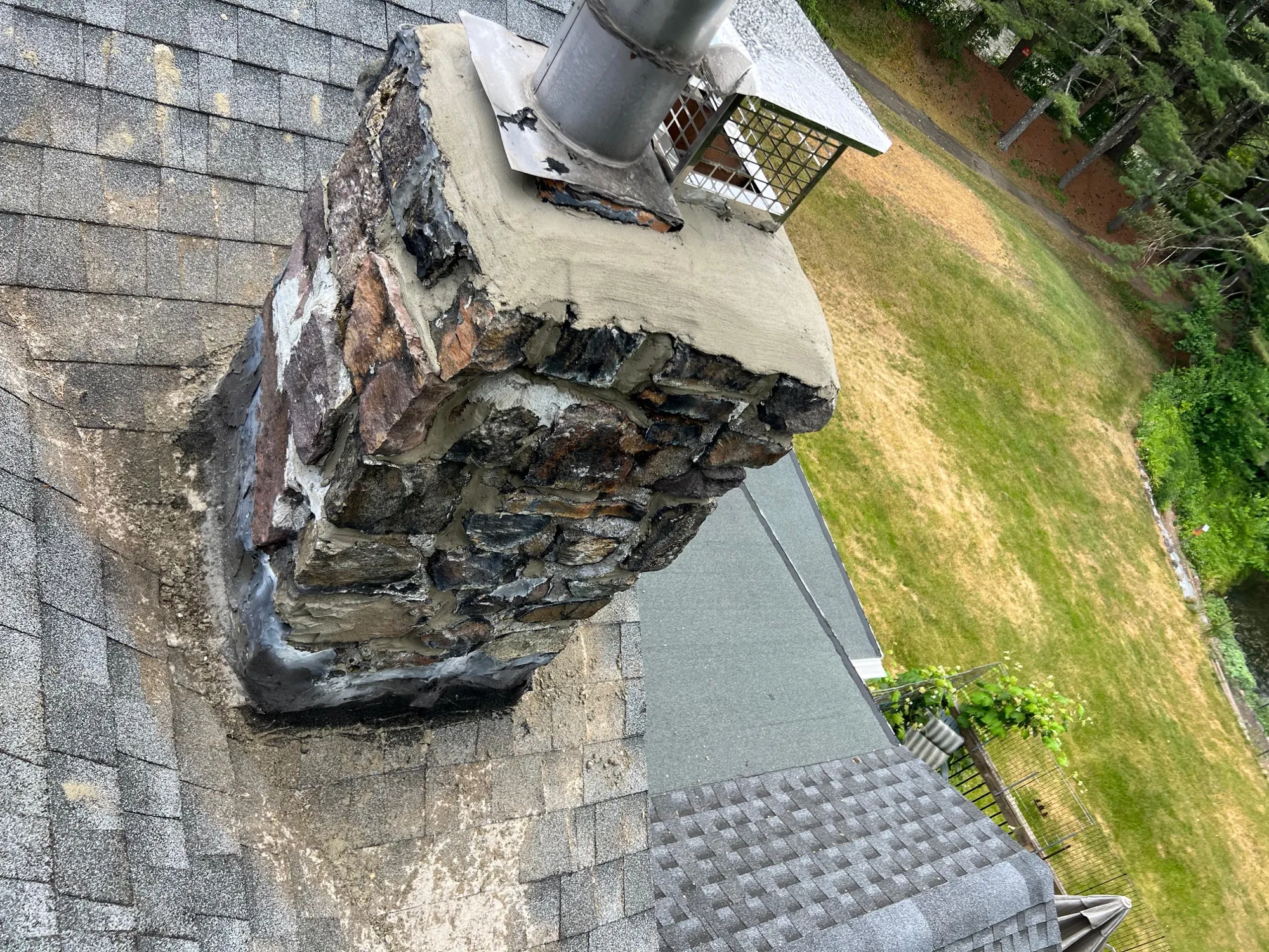Severely damaged brick chimney showing crumbling mortar