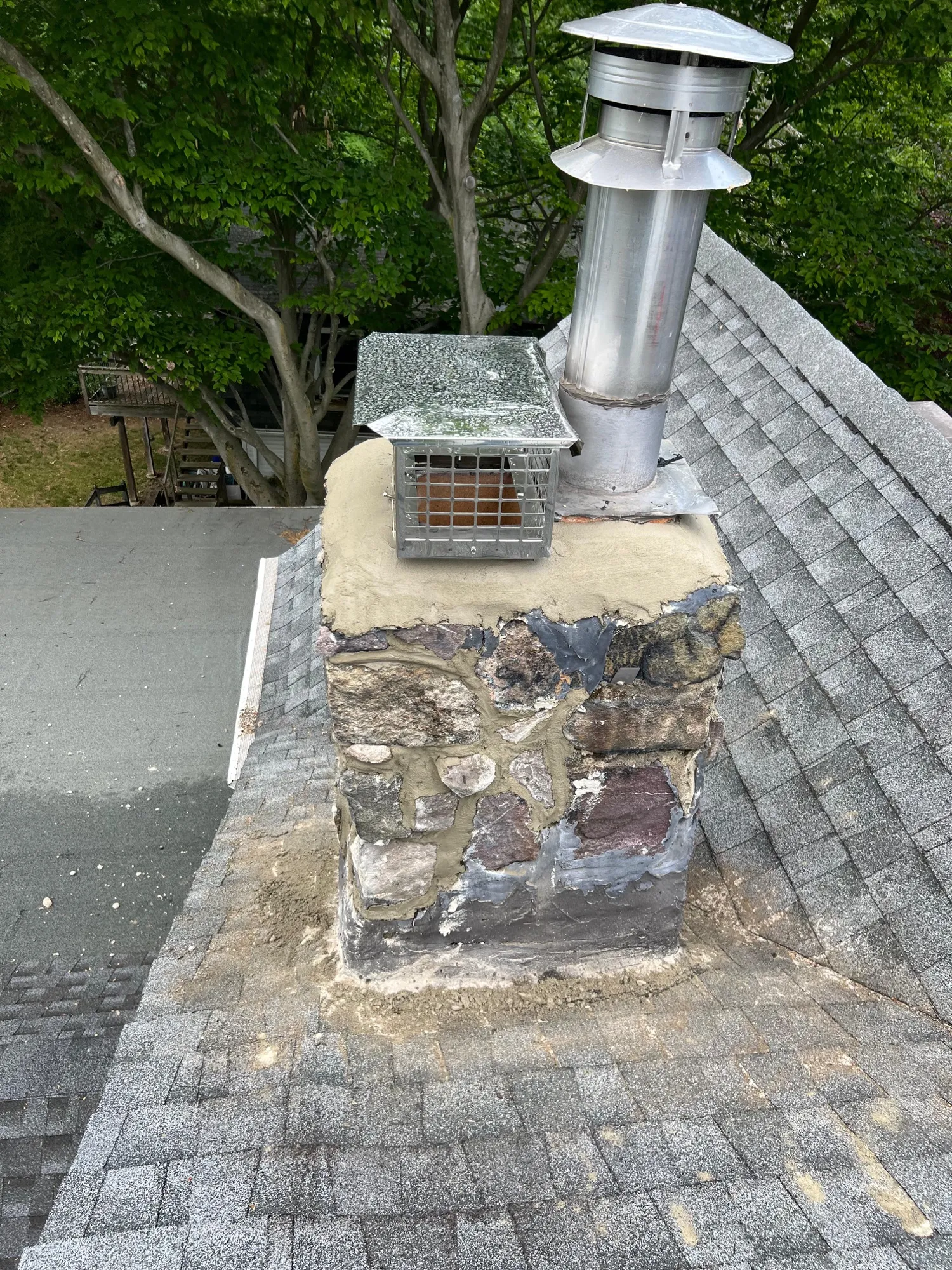 Damaged chimney with new shingles around it